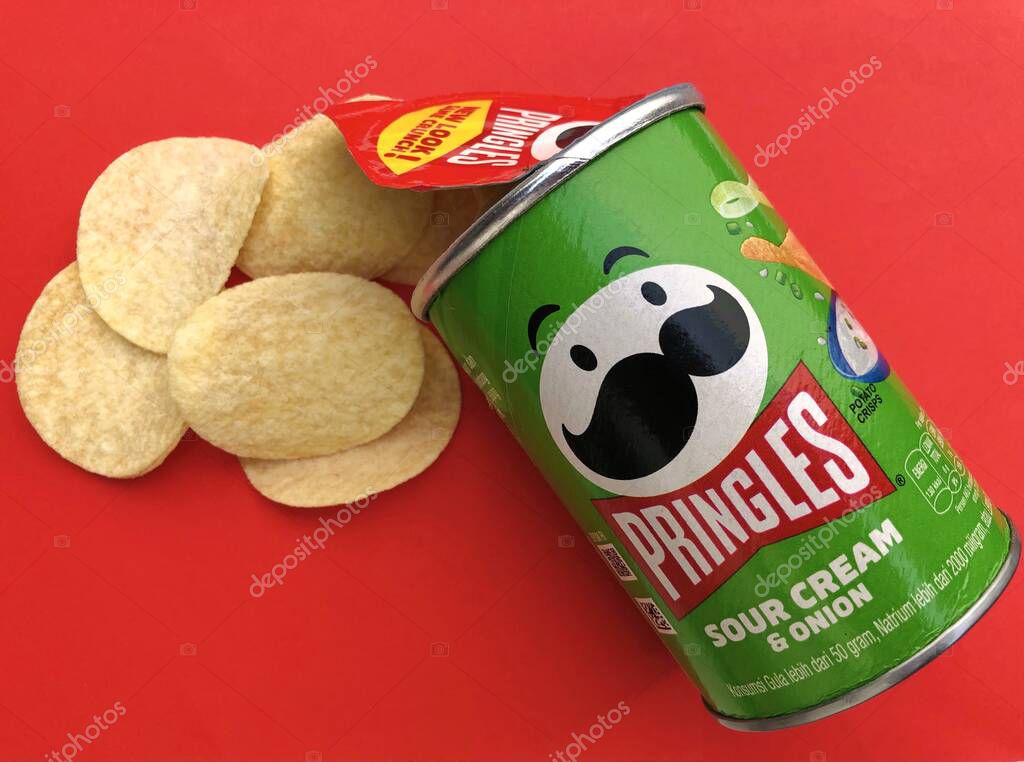 Malang, Indonesia - Jun 23th 2022: Pringles Sour Cream and Onion. With green cardboard tube packaging. Pringles is a brand of potato snack chips owned by the Kellogg Company.