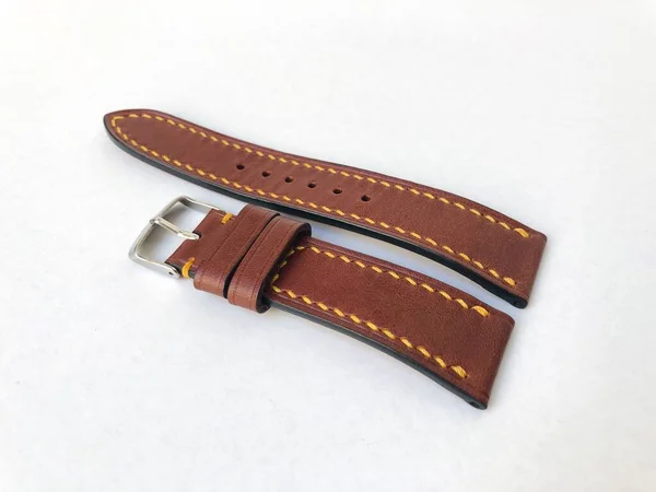 Handmade brown leather watch strap isolated on a white background.