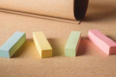 Pile colored block of post notes  on brown craft paper background , closeup