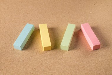 Pile colored block of post notes  on brown craft paper background , closeup