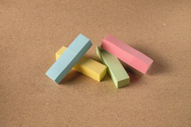 Pile colored block of post notes  on brown craft paper background , closeup