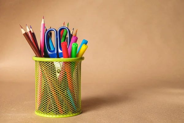 Set of colorful school stationery on brown background.  With space for text 