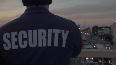 Security guard looking down street and sunset