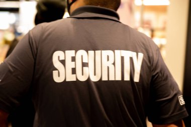 Ticari binada devriye gezen üniformalı güvenlik görevlisinin dikiz görüntüsü..