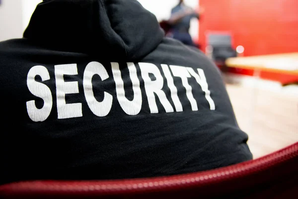 Security guard in uniform in a company meeting room.