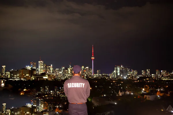 Security guard patrolling city streets at night