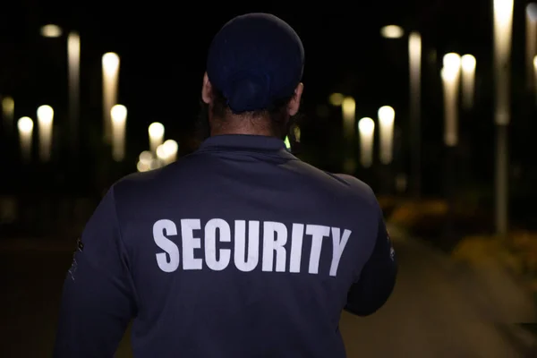 Security guard patrolling city streets at night