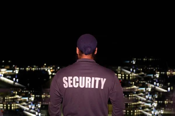 Security guard patrolling city streets at night