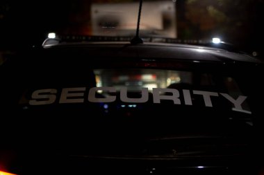 Gece yarısı inşaat sahasında devriye gezen güvenlik arabası.