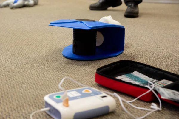 Staff setting AED machine to practice first aid