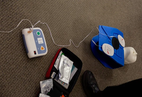 Staff setting AED machine to practice first aid