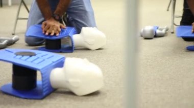Staff is training to conduct first aid CPR with a dummy doll and AED machine