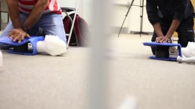 Staff is training to conduct first aid CPR with a dummy doll and AED machine