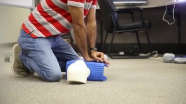 Staff is training to conduct first aid CPR with a dummy doll and AED machine