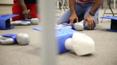 Staff is training to conduct first aid CPR with a dummy doll and AED machine