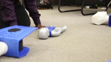 Staff is training to conduct first aid CPR with a dummy doll and AED machine
