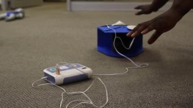 Staff is training to conduct first aid CPR with a dummy doll and AED machine