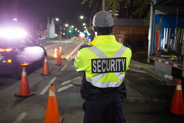 Security guard patroling at construction site at night  city
