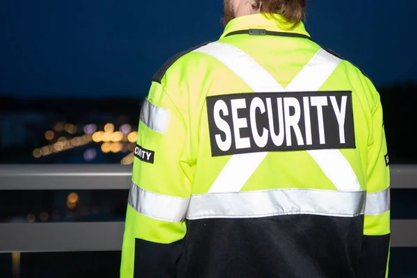 security guard walking through the street of the big city at night.