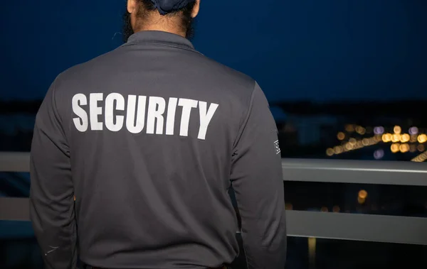 security guard walking through the street of the big city at night.