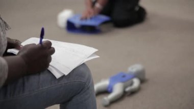 Staff is taking down a note in cpr first aid class