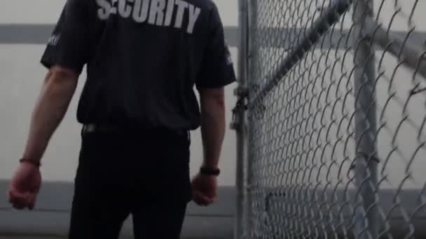 Egy Biztonsági Járőrözik Egy Bekerített Kereskedelmi Területen — Stock videók