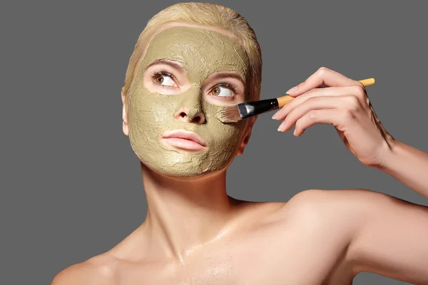 使用绿色面罩的漂亮女人 美容美发浅谈矿泉女孩在灰色背景下使用粘土面膜的特写 — 图库照片