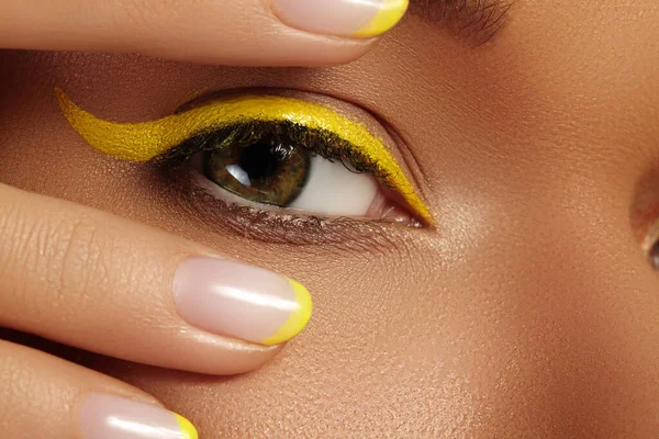 Крупный план Женский глаз с ярко-желтым макияжем. Неоновый диско макияж и маникюр. Летний стиль красоты — стоковое фото