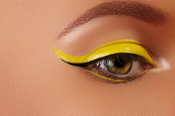 Occhio femminile primo piano con trucco eyeliner giallo brillante. Neon Disco make-up e moda manicure. Stile di bellezza estivo — Foto Stock
