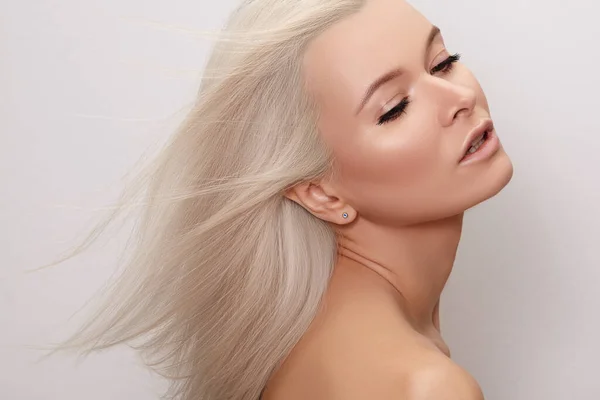 Όμορφη γυναίκα με υπέροχα ξανθά μαλλιά. Ευτυχισμένο μοντέλο προσώπου με ανεμοδαρμένα ιπτάμενα μαλλιά. Λαμπερό μακρύ χτένισμα υγείας — Φωτογραφία Αρχείου
