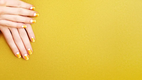 Beautiful Female Hands Bright Orange Manicure Candy Corn Yellow Background — Stok fotoğraf