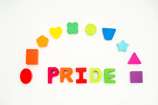 Word pride in colored block lettering with colored rainbow shapes in background. High quality photo. Love is love. Celebrating pride.