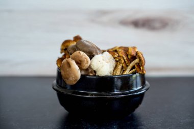 Koyu siyah arka planda aslanlar yelesi, istiridye, tarçın kepi ve şiitake karışımı yabani mantar karışımı. Yüksek kalite fotoğraf. Yenilebilir iyilik..