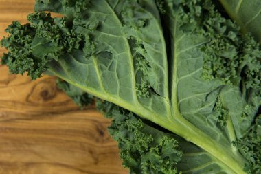 Bunch of organic fresh kale on grainy wooden background. High quality photo