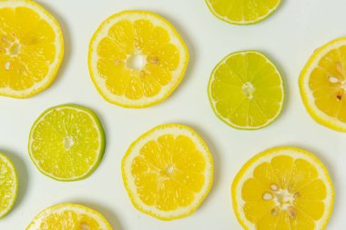 Fresh organic simple green lime and yellow lemon slice on white background. High quality photo.
