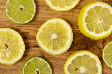 Fresh organic simple green lime and yellow lemon slice on wood grain rustic background. High quality photo.