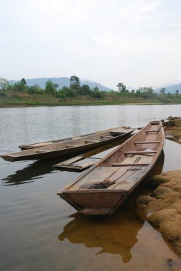 Wooden fishing boats docked on the side of the Mekong River in Laos, Asia . High quality photo