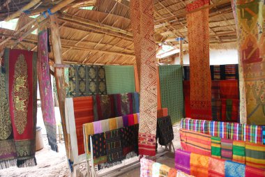 Traditional Loas weaving village with textiles hung in straw hut. High quality photo.