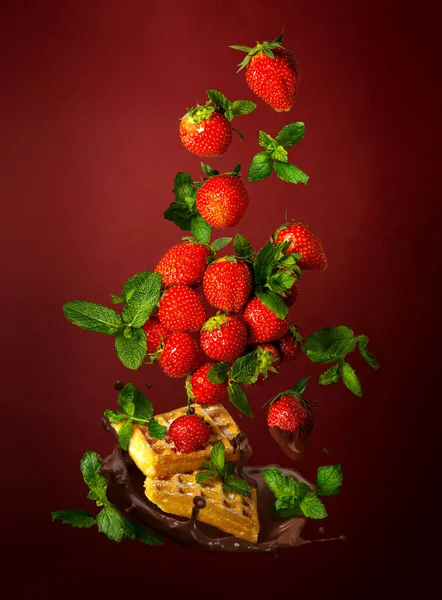 イチゴと緑の葉にワッフルマフィンとチョコレートアイシングをブルゴーニュを背景に — ストック写真
