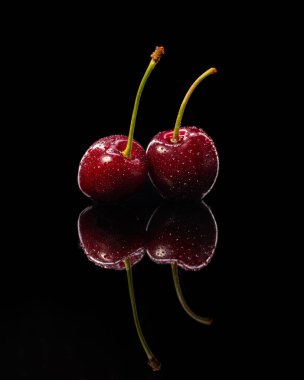 Siyah ahşap bir masada olgun bir kiraz.