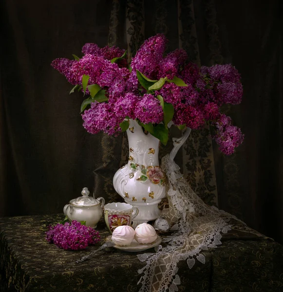 bouquet of burgundy lilacs in a vase and marshmallow dessert