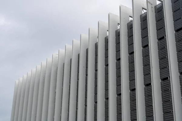 ARCHITECTURE BUILDING WITH VERTICAL WHITE LINES WITH CLOUDY SPRING DAY