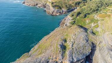 Güneşli bir yaz gününde Cantabrian sahilinin arka planında köyün ve plajın insansız hava görüntüsü..