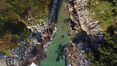 Dalgaların güneşli bir günde kayalara çarptığı Cantabrian kıyılarının insansız hava görüntüsü.