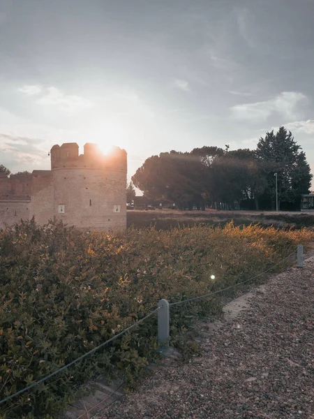 Ancient medieval castle with moat in front at sunset with the sun beating on the tower in Spain.