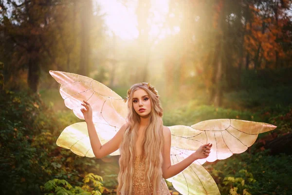 Fantasy woman fairy fashion model in fabolous summer forest. Girl elf goddess of nature. Golden pixie wings costume, sexy shiny glow dress. Cute face lady princess queen of butterfly, sun magic light — Stock Photo, Image