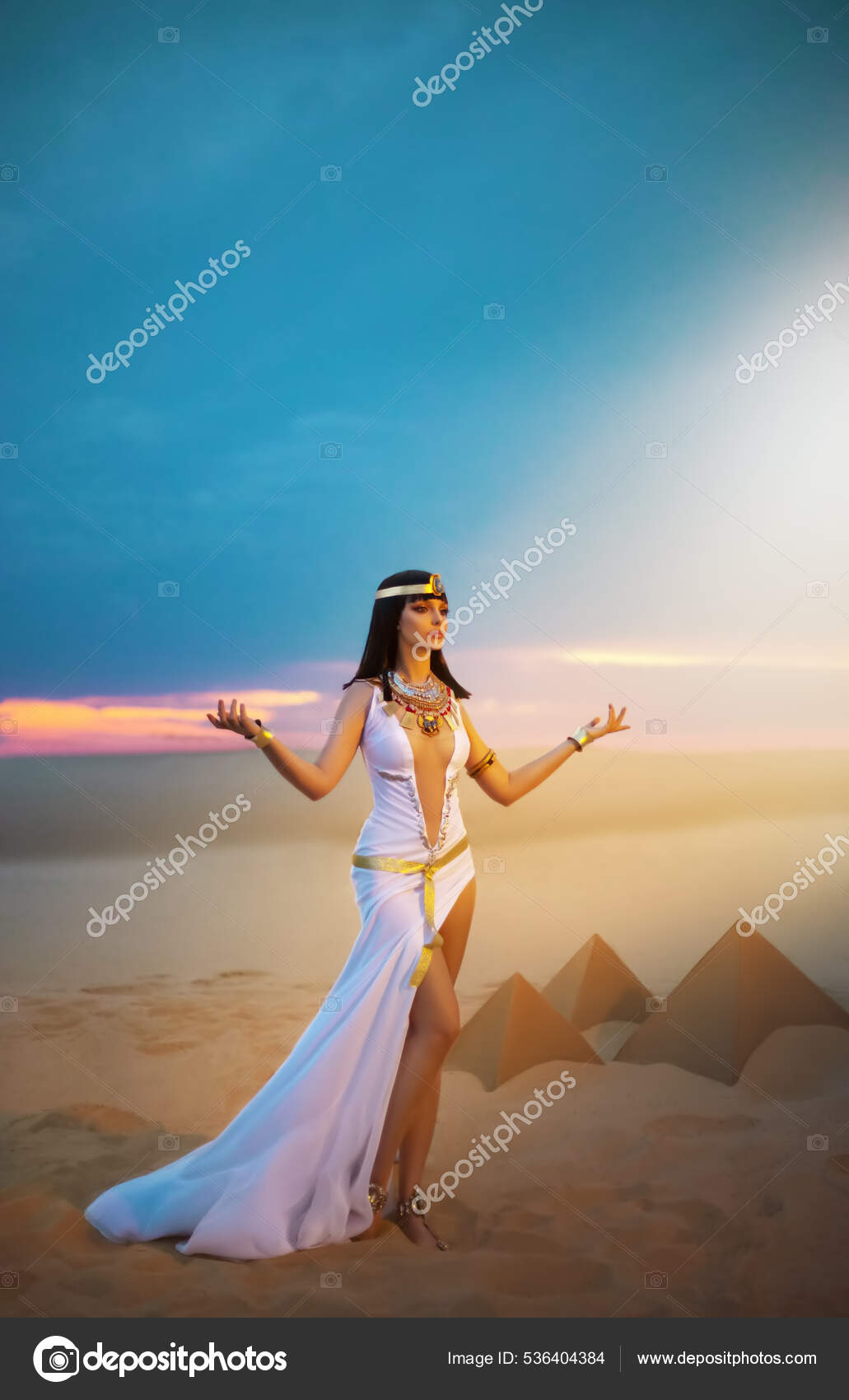 Egypten Kvinde hedning beder hænder hævet til himlen blå himmel. Sexet pige  egyptisk gudinde Dronning Cleopatra. gule sand Sahara ørken pyramider. Art  gamle farao kostume hvid kjole guld tilbehør krone. — Stockfoto ©, image size:1031x1700