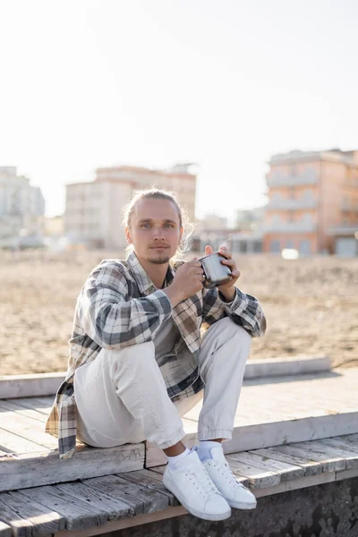 Young Man Shirt Holding Metal Cup While Sitting Pier Treviso — Stock Photo, Image