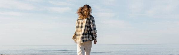 Back view of long haired man standing near adriatic sea in Treviso, banner 