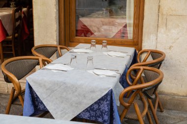 Venedik 'teki kafe terasında, çatal bıçaklı ve boş bardaklı sandalyeler.